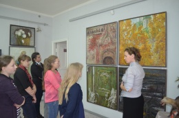 Н. Н. Ветрова проводит в выставочном зале Енисейска экскурсию со своими учениками.
